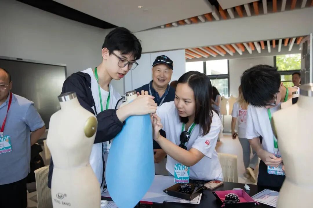 Participants experiment with fabrics and accessories in fashion design at YWIES Zhejiang Tongxiang