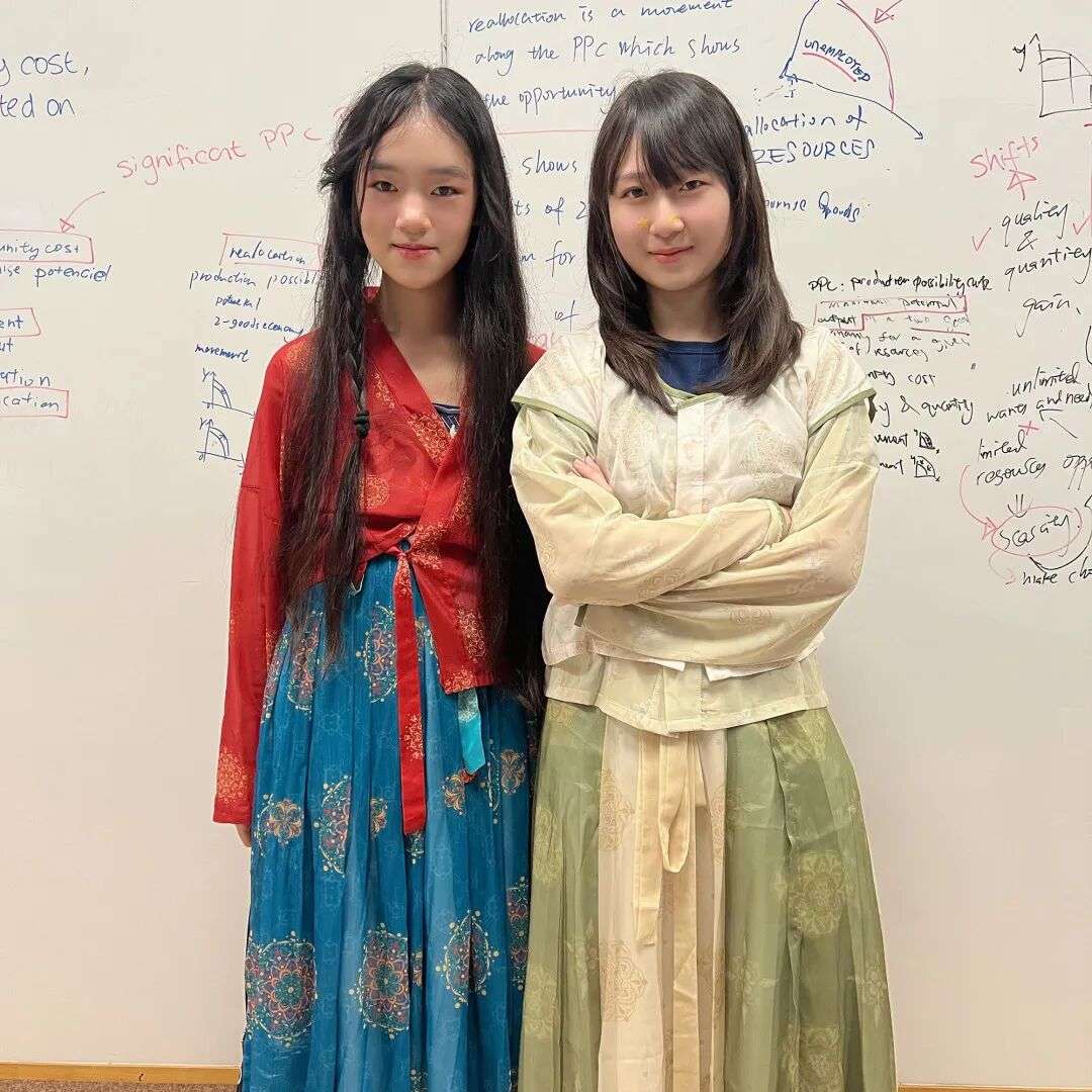 汉服日现场，学生与老师穿着汉服在校园中合影，洋溢中秋活动氛围