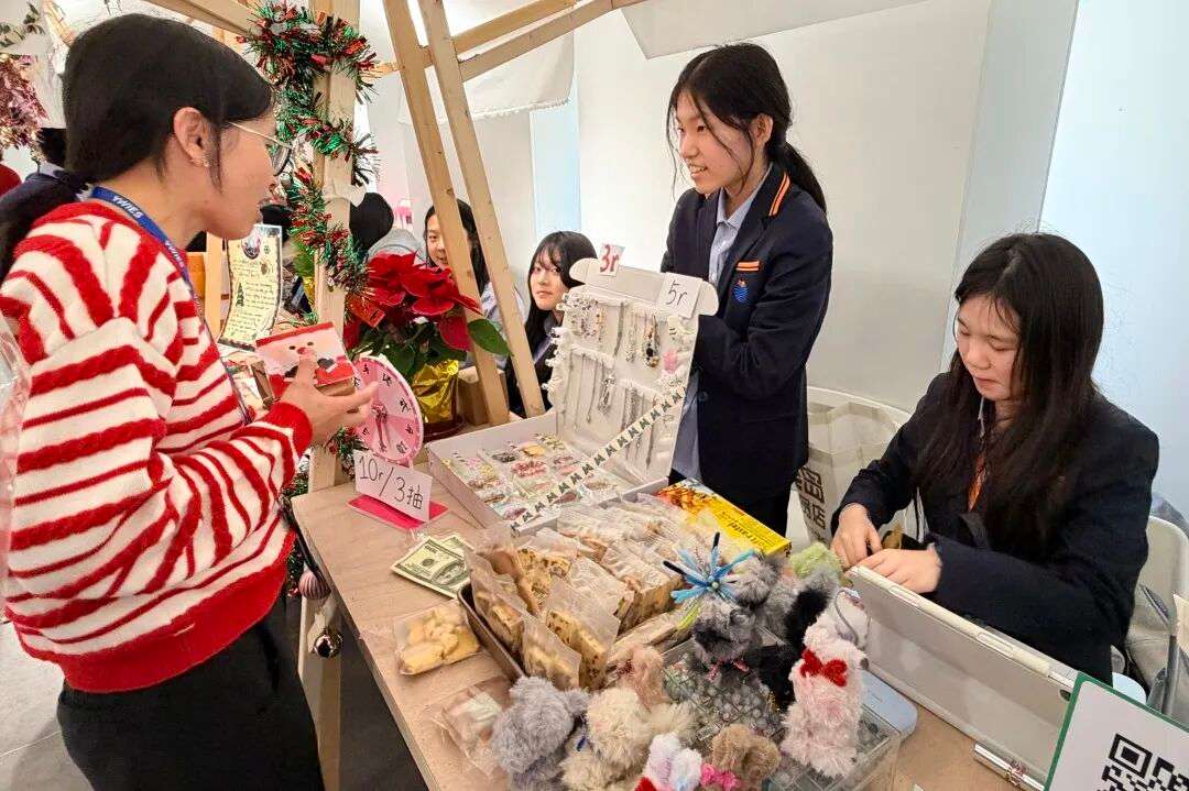 学生在暖冬集市摊位售卖亲手制作的饰品与礼物