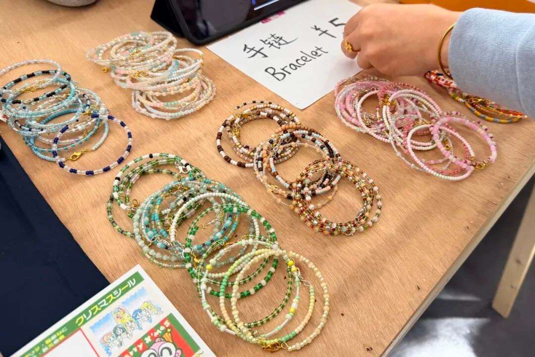 家长与老师挑选学生手作礼品，支持暖冬集市